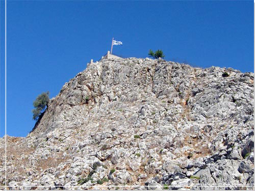 Det grske flag vajer fra et lille fort. En militr forpost af en art